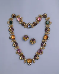 En fin Regency halskæde i guld og juveler prydet med pudeskåret topas, ametyster, lyserøde turmaliner, smaragder, safirer og periodotter, med et par blomstrede øreringe, ca. 1810