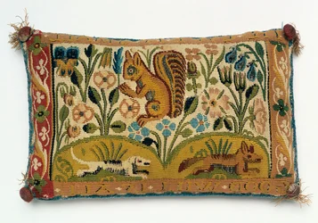 Et tapestry-panel med nålepude med et egern og motto "god vilje er alt"