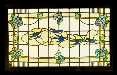 Arts and Crafts panel af en gruppe svaler før skyer i en kant af stiliserede blomsterhoveder (blyet og farvet glas)