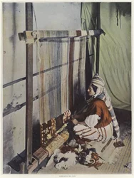 En kvinde, der væver et gobelin på en væv i Tunesien