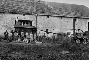 Landbrugsarbejdere og pressen bandt høstøvler på en gård nær Bourmont i Haute-Marne (Haute Marne), omkring 1890. Fotografi. Ducos samling.