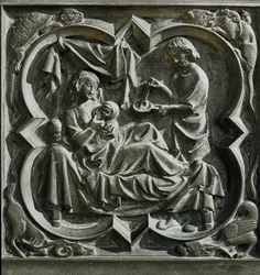 Adam laver mad, mens Eva ligger i sengen og ammer et barn ... (relief)