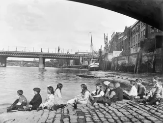 Børn på den brostensbelagte dæmningsvej under Southwark Bridge, London, c1930