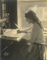 Mary Pickford skriver ved et skrivebord, ca. 1918 (s/h-foto)