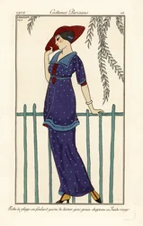 Kvinde i strandkjole af foulard dekoreret med store prikker, rød ruskindshat. Robe de plage en foulard garni de tussor gros grain, chapeau en ruskind rouge. Håndfarvet pochoir (stencil) radering efter en illustration af George Barbier fra Tommaso Antongini