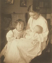 [Mor i morgenkåbe, siddende, med spædbarn og lille søn].