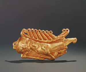 Liggende kronhjort, dekoreret på kroppen med figurer af bevinget griffin, hare, løve, hund og vædderhoved (guld)