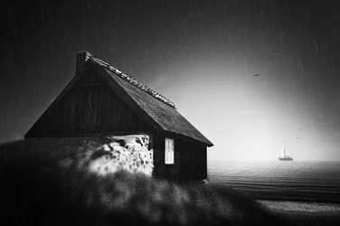 Et hus ved havet i regnvejr