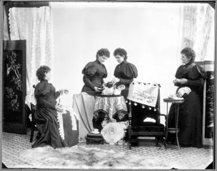 Dobbelt eksponering af Hannah Maynard - to drikker te, en holder et bundt bomuldsgarn, en vinder det op til et nøgle, ca. 1895