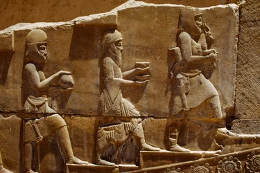 Reliefskulptur af mænd, der bærer offergaver på murene i Persepolis. Persepolis, Iran.