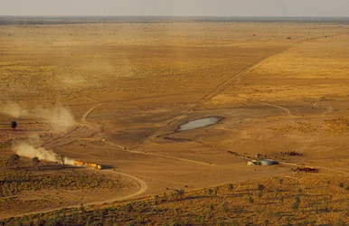 Lastvognstog med kvæg krydser et uvejsomt plateau i outbacken. Vestaustralien, Australien.