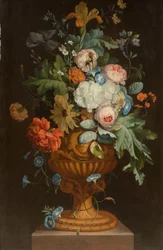 Blomster i en terracotta-vase på en piedestal