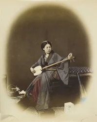 Kvinde spiller shamisen (håndfarvet sort/hvid foto)