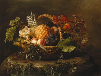 En ananas, druer, ferskner og abrikoser i en kurv,
