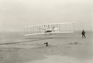 Wright Flyer I laver sin første flyvning på 120 fod på 12 sekunder i Kitty Hawk, North Carolina