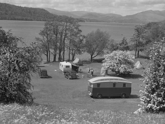 Telte og campingvogne sat op på en mark ved Wastwater, søen og fjeldene i baggrunden