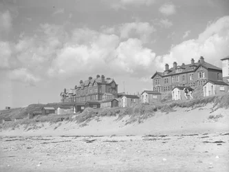 Udsigt fra Silloth-stranden over strandhytter og huse langs havet; havlandskab; front