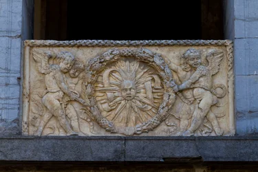 Balustradeplade med strålende sol i guirlande, basrelief på facaden af San Sebastiano kirken