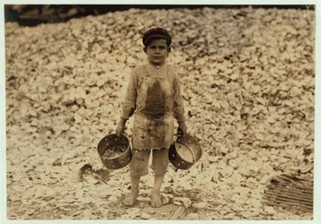 Den 5-årige migrantrejeplukker Manuel foran en bunke østersskaller, arbejder i et andet år hos Dunbar, Lopez, Dukate Company, Biloxi, Mississippi, 1911