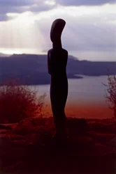 Kykladisk idol på baggrund af kysten ved solnedgang, Kykladerne, Grækenland, kykladisk civilisation (foto)