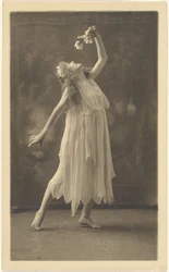 [Kvindelig danser med blomst foran et vægtæppe]