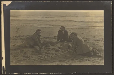 [Figurer siddende på stranden]