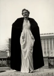 Model i aftenkjole, en kreation af couture-huset "Graldi". Artiklen er suppleret med en pels-trimmet kappe. (s/h foto)