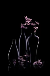 Lyserøde blomster i mørke vaser