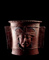 Præcolumbiansk kunst, mayacivilisationen, senklassisk periode: cylindrisk gravurne af ler dekoreret med et menneskeansigt. Fra Quiché, Guatemala. Mål: højde 38.5 x diameter 39,5 cm. Guatemala, Det Nationale Museum for Arkæologi og Etnologi