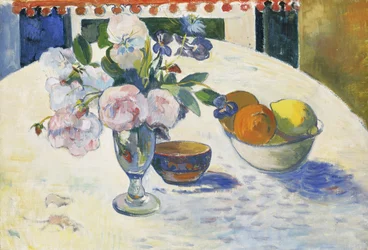 Blomster og en skål frugt på et bord