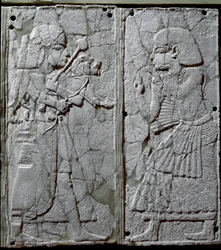 Fønikisk civilisation: sengeornament dekoreret med et lavt relief i elfenben, der viser en vagt, som præsenterer en løve for kongen. Fra fundstedet Ugarit, en oldtidssyrisk by på Tell Ras Shamra. 14. århundrede f.Kr. Mål 24 cm. Damaskus, Nationalmuseet
