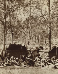 Australske aboriginer i læ bag et læhegn (s/h-billede)