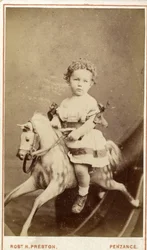 Ung pige sidder på en gyngehest, 1860