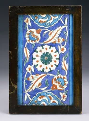 En Iznik-kantflise med et centralt blomsterhoved mellem rullepalmet og grøn vin, ca. 1570 (keramik)