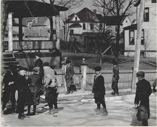 En gruppe drenge i vinterfrakker, der står på en uidentificeret gade enten før eller efter en skoledag.
