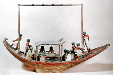 Gammel egyptisk model af en båd, der bærer en mumie til sin grav