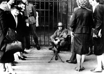 Civile foran en tysk vagtpost med maskingevær, Paris, juni 1940