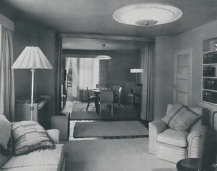 Spisestue og stue, kun opdelt af tunge gardiner i en attraktiv moderne vævning, 1942