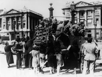 Franske gadesælgere tilbyder souvenirs til en lastbil med tyske soldater, Paris, 27. juli 1940