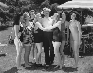 Hollywood, Californien: ca. 1935 Syv unge kvinder i badedragter kæmper om en enkelt mands opmærksomhed. (s/h foto)