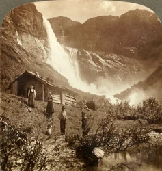 Ydmygt bjerghjem ved foden af klipper, hvor Skiaeggedals Falls springer 525 ft., Norge, c1905.