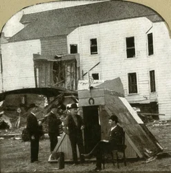 Flygtningelejr, tidligere bolig i ruiner i baggrunden. Dette er jordskælvsarbejde, 1906.