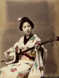 En geisha, der spiller shamisen (farvet foto)