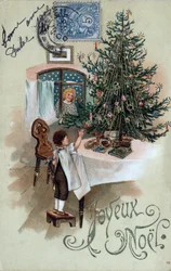Jule lykønskningskort: et barn foran et juletræ poserer på et bord, observeret af en engel i vinduet - Postkort dateret 1905