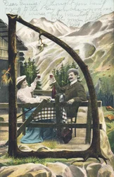 D: En mand og en kvinde, der sidder ved et bord foran en bjerghytte, klirrer i glas, et glas vin i hænderne - Alfabettegn Ref Th. E., L. Theochrom - Serie 994. Theodor Eisman, udgiver, Leipzig