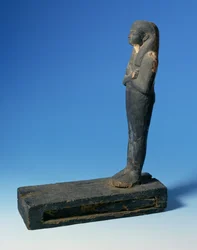 Ptah-Sokar-Osiris figur med tredelt paryk og krydsede arme på en rektangulær sokkel med et rum indeholdende et udsnit af papyrus (se 83304), egyptisk, 21.-22. dynasti, ca. 900 f.Kr. (træ) (for detaljer se 83306)