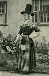 Wales. En statelig ældre walisisk dame, som urokkeligt holder fast ved nationaldragten. 1920