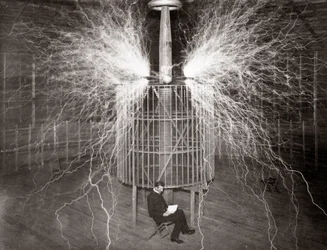 Nikola Tesla sidder i sit Colorado Springs laboratorium med sin "magnifying transmitter"