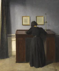 Ida står ved et skrivebord, 1900