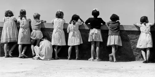 Gruppe af børn, der læner sig op ad et brystværn, Italien, ca. 1960 (gelatinesølvtryk)
